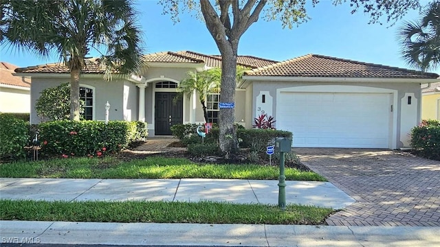 3940 Ruxton Rd, Naples, FL 34116 - mediterranean / spanish home featuring stucco siding, a garage, driveway, and a tile roof