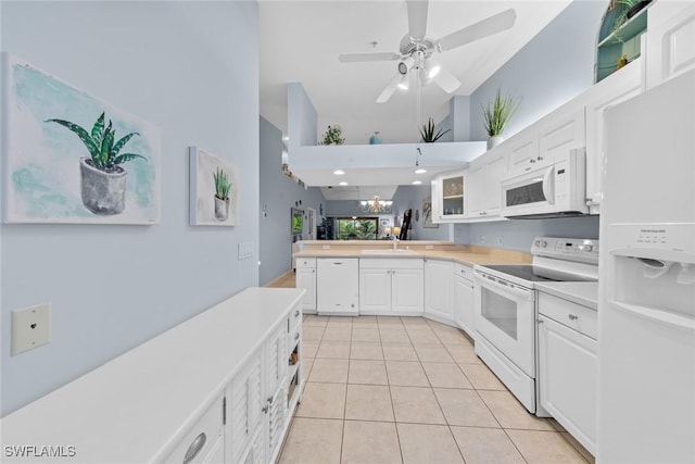 2365 Bayou Ln Unit 10, Naples, FL 34112 - kitchen featuring white appliances, high vaulted ceiling, a peninsula, light tile patterned flooring, and white cabinetry