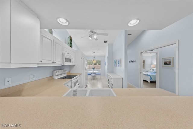 2365 Bayou Ln Unit 10, Naples, FL 34112 - kitchen with white appliances, ceiling fan, white cabinets, light countertops, and lofted ceiling