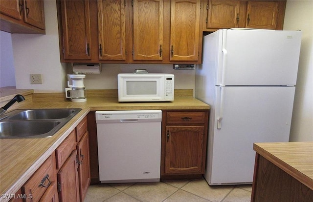 4265 Bay Beach Ln Unit 524, Fort Myers Beach, FL 33931 - kitchen with white appliances, light countertops, brown cabinets, and light tile patterned floors