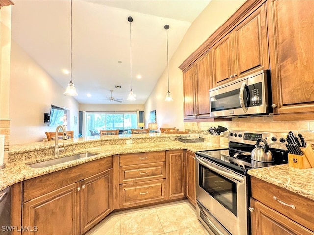 7066 Barrington Cir Unit 201, Naples, FL 34108 - kitchen featuring appliances with stainless steel finishes, brown cabinetry, light stone counters, vaulted ceiling, and recessed lighting