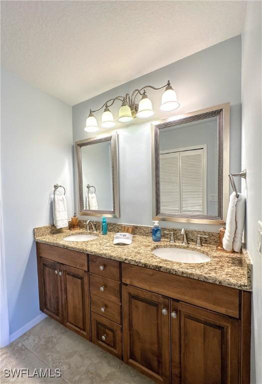 7066 Barrington Cir Unit 201, Naples, FL 34108 - bathroom with double vanity and tile patterned floors