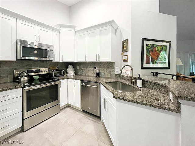 3620 Stone Way, Estero, FL 33928 - kitchen with stainless steel appliances, a peninsula, tasteful backsplash, and white cabinets
