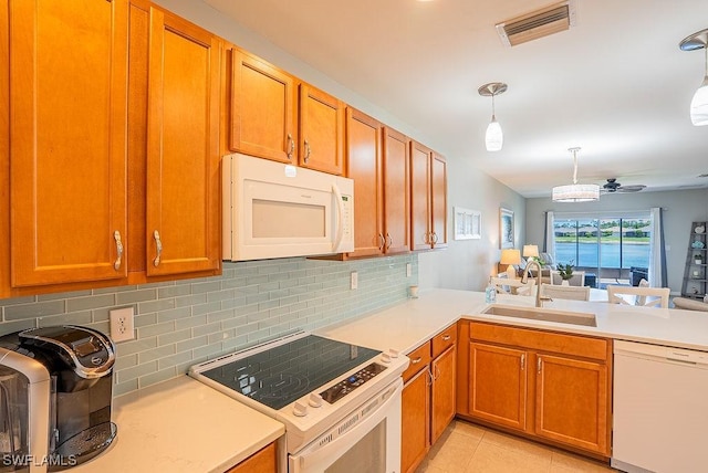 20050 Fiddlewood Ave, North Fort Myers, FL 33917 - kitchen featuring white appliances, light countertops, backsplash, and brown cabinets