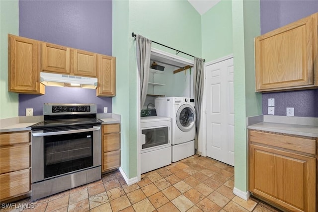 509 Scott Ave, Lehigh Acres, FL 33972 - kitchen with electric range, under cabinet range hood, washer and dryer, light brown cabinets, and stone tile floors