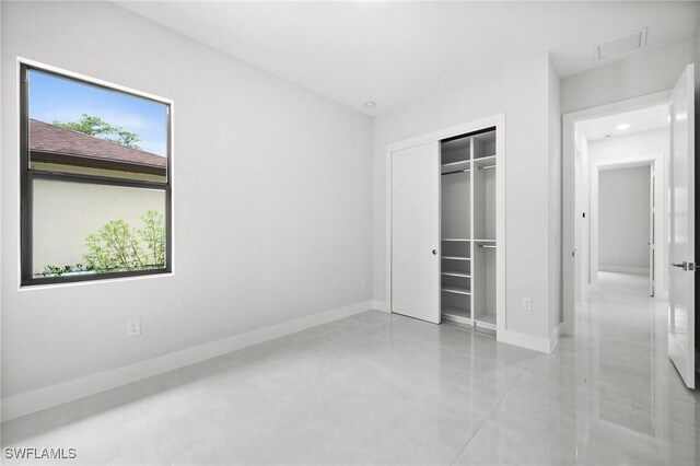 4211 12th Ave NE, Naples, FL 34120 - unfurnished bedroom featuring a closet, recessed lighting, and light tile patterned flooring