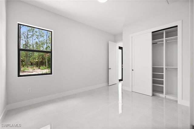 4211 12th Ave NE, Naples, FL 34120 - unfurnished bedroom featuring light tile patterned flooring and a closet
