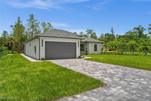 4211 12th Ave NE, Naples, FL 34120 - view of front of house with an attached garage, a front lawn, stucco siding, and decorative driveway