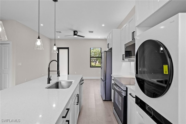 1201 E 7th St, Lehigh Acres, FL 33972 - kitchen featuring stainless steel appliances, light wood-style flooring, white cabinetry, pendant lighting, and ceiling fan