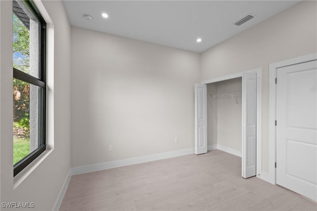 1201 E 7th St, Lehigh Acres, FL 33972 - unfurnished bedroom featuring multiple windows, light wood-type flooring, and recessed lighting