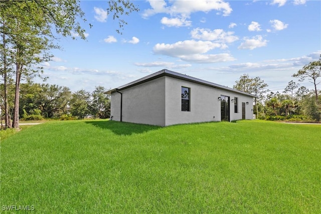 1201 E 7th St, Lehigh Acres, FL 33972 - view of property exterior featuring stucco siding and a yard