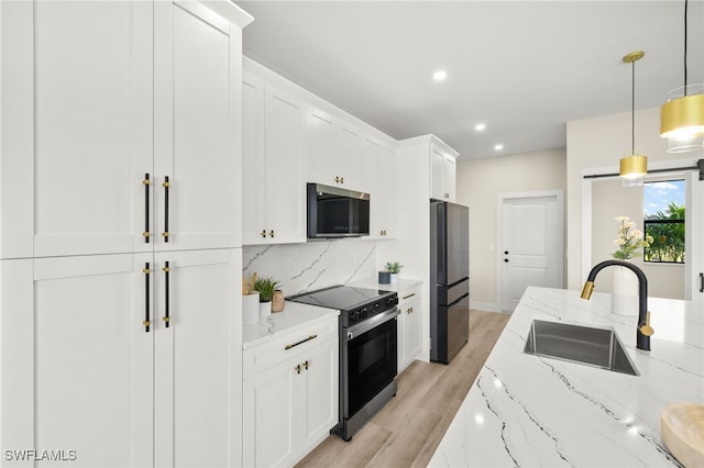 3008 20th St SW, Lehigh Acres, FL 33976 - kitchen featuring stainless steel appliances, white cabinetry, light wood finished floors, tasteful backsplash, and light stone counters