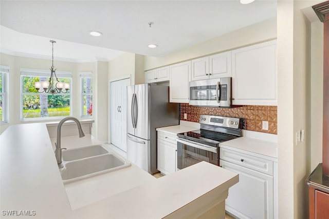 20010 Barletta Ln Unit 612, Estero, FL 33928 - kitchen with appliances with stainless steel finishes, white cabinets, tasteful backsplash, hanging light fixtures, and light countertops