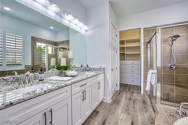 13461 Sabal Pointe Dr, Fort Myers, FL 33905 - bathroom featuring double vanity, a shower stall, and wood finished floors