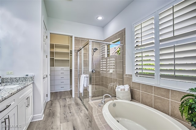 13461 Sabal Pointe Dr, Fort Myers, FL 33905 - bathroom with a garden tub, a shower stall, vanity, wood finished floors, and recessed lighting