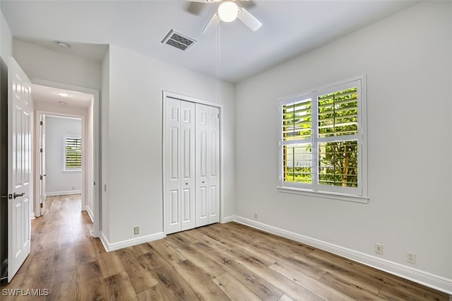 13461 Sabal Pointe Dr, Fort Myers, FL 33905 - unfurnished bedroom with multiple windows, wood finished floors, and a closet