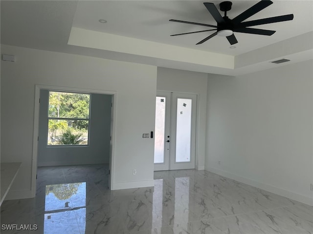 1402 Henry Ave, Lehigh Acres, FL 33972 - empty room featuring marble finish floors, french doors, ceiling fan, and a tray ceiling