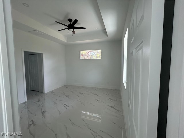 1402 Henry Ave, Lehigh Acres, FL 33972 - empty room with a ceiling fan, a raised ceiling, and marble finish flooring
