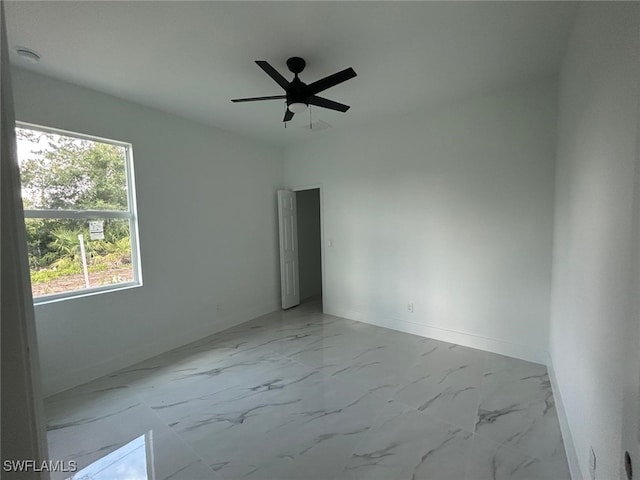 1402 Henry Ave, Lehigh Acres, FL 33972 - empty room with light marble finish floors and ceiling fan