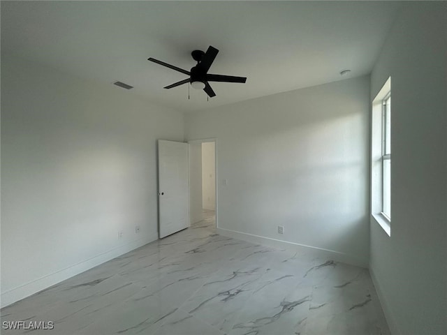 1402 Henry Ave, Lehigh Acres, FL 33972 - spare room featuring light marble finish floors and a ceiling fan