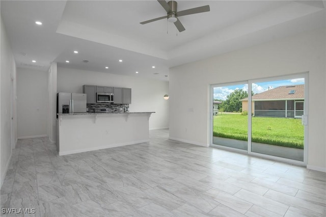 311 Rand Ave, Lehigh Acres, FL 33974 - unfurnished living room featuring ceiling fan, recessed lighting, and a tray ceiling