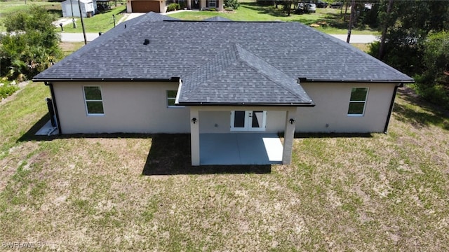 4204 E 24th St, Alva, FL 33920 - back of house with a shingled roof, a patio, stucco siding, and a lawn