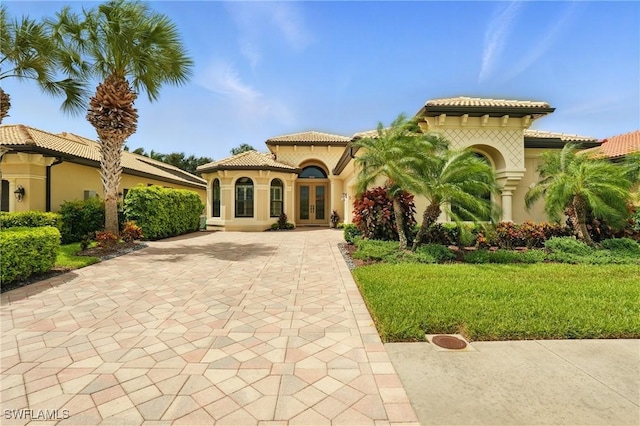 23484 Sanabria Loop, Bonita Springs, FL 34135 - mediterranean / spanish home with french doors, stucco siding, and a tiled roof