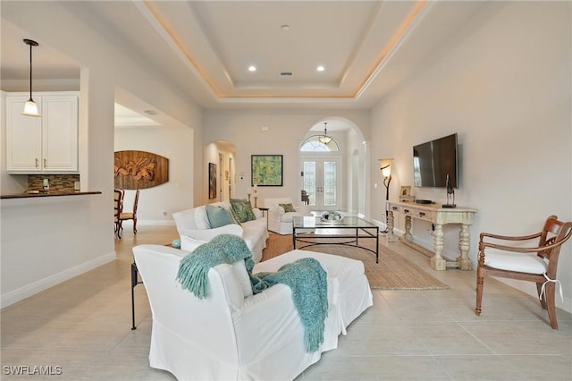 23484 Sanabria Loop, Bonita Springs, FL 34135 - living room with arched walkways, recessed lighting, a tray ceiling, and light tile patterned floors