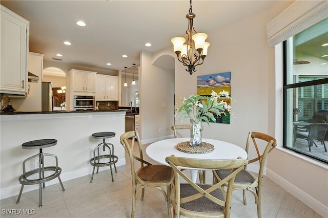 23484 Sanabria Loop, Bonita Springs, FL 34135 - dining area with arched walkways, recessed lighting, and a chandelier