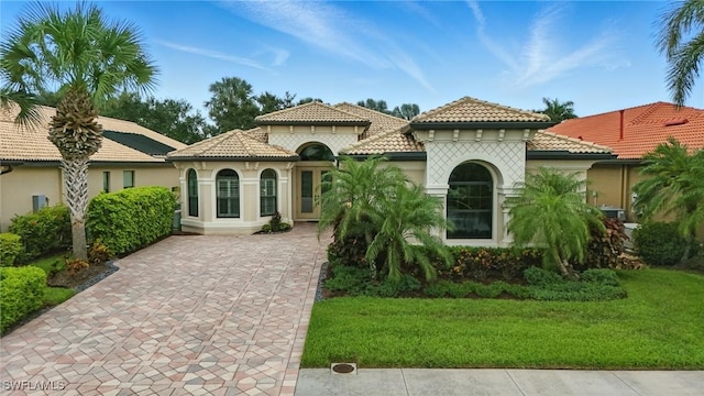 23484 Sanabria Loop, Bonita Springs, FL 34135 - mediterranean / spanish-style home featuring a tiled roof, concrete driveway, a front yard, and stucco siding