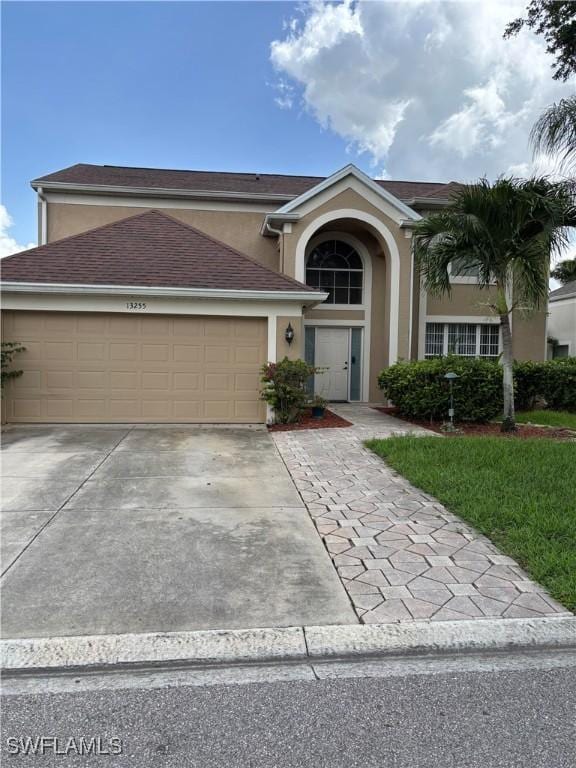 13255 Highland Chase Pl, Fort Myers, FL 33913 - traditional-style home with stucco siding, an attached garage, and driveway