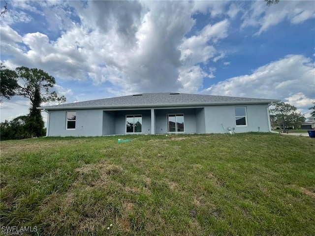 4605/4607 30th St SW, Lehigh Acres, FL 33973 - back of property featuring stucco siding and a lawn