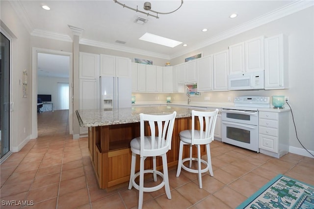 922 Turtle Ct Unit 21-21, Naples, FL 34108 - kitchen with white appliances, light tile patterned floors, white cabinets, a kitchen island, and crown molding