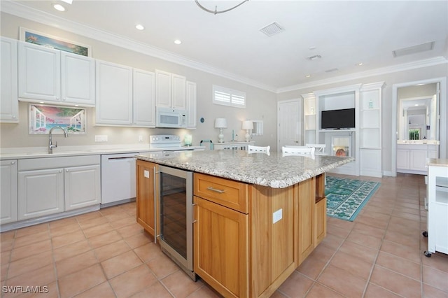 922 Turtle Ct Unit 21-21, Naples, FL 34108 - kitchen with white appliances, wine cooler, a kitchen island, ornamental molding, and light tile patterned flooring