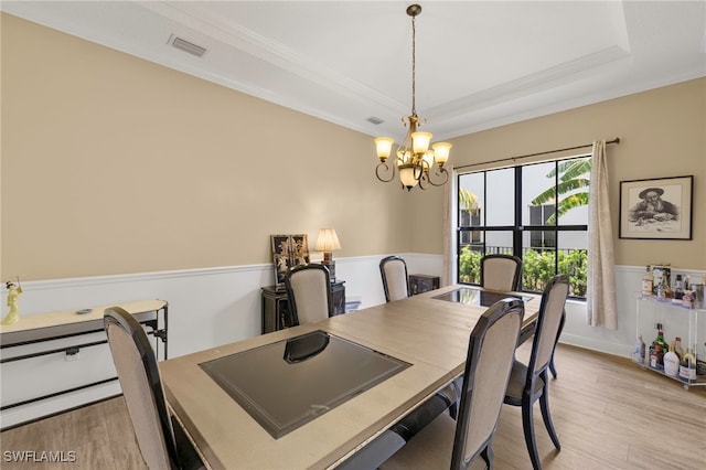 5158 Roma St, Ave Maria, FL 34142 - dining space with light wood-style flooring, a chandelier, ornamental molding, and a tray ceiling
