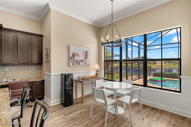 5158 Roma St, Ave Maria, FL 34142 - dining area with light wood finished floors, crown molding, a water view, a desk, and a chandelier