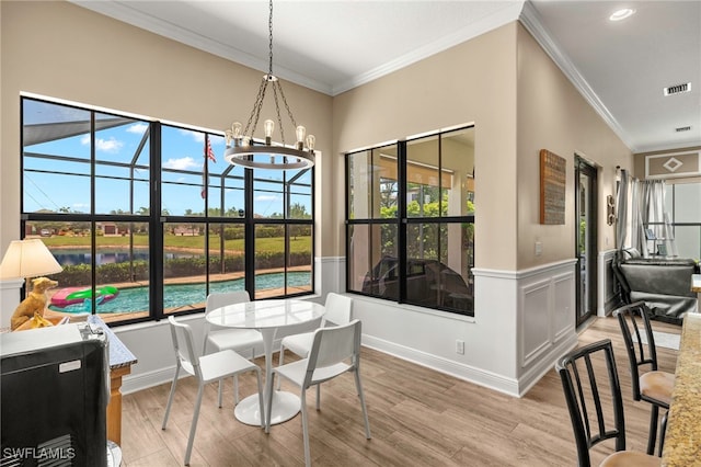 5158 Roma St, Ave Maria, FL 34142 - dining space featuring light wood-style flooring, crown molding, a chandelier, and a sunroom
