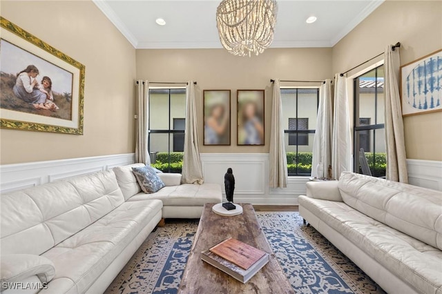 5158 Roma St, Ave Maria, FL 34142 - living room featuring a chandelier, wainscoting, crown molding, wood finished floors, and a decorative wall