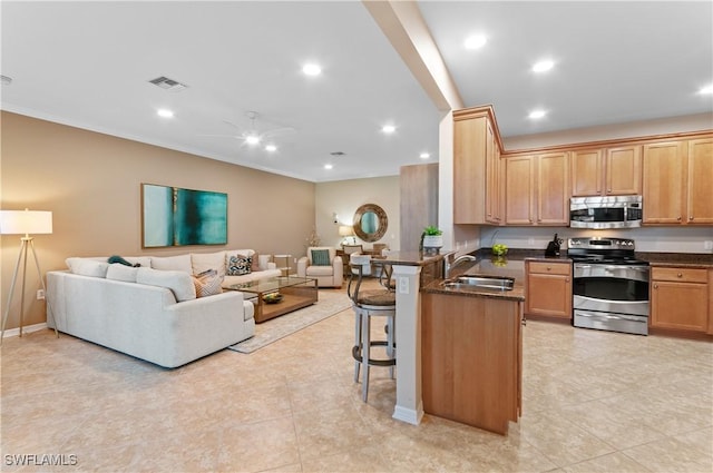 12085 Via Siena Ct Unit 102, Bonita Springs, FL 34135 - kitchen with appliances with stainless steel finishes, open floor plan, a breakfast bar, a peninsula, and ceiling fan