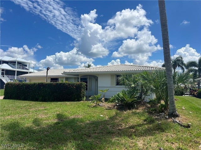 3 Palmview Blvd, Fort Myers Beach, FL 33931 - view of property exterior featuring a lawn, a tiled roof, and stucco siding