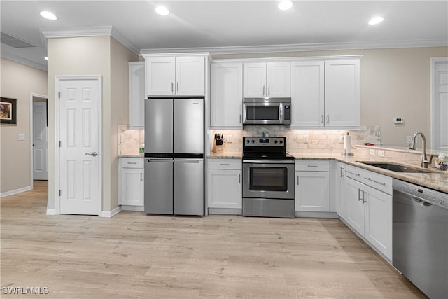 10736 Cetrella Dr, Fort Myers, FL 33913 - kitchen with stainless steel appliances, ornamental molding, decorative backsplash, white cabinets, and recessed lighting