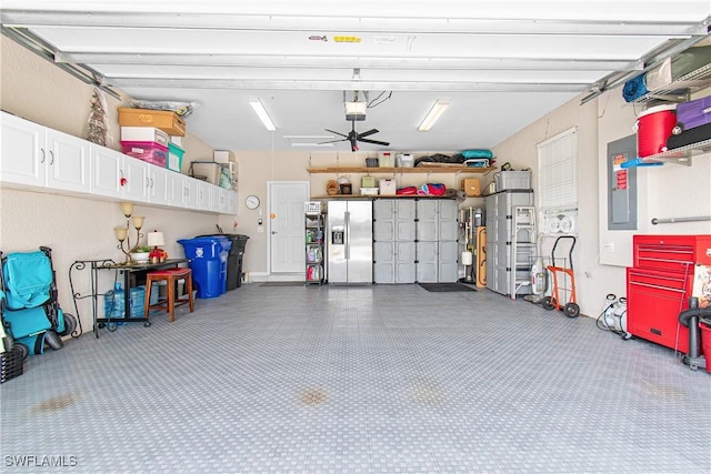 10736 Cetrella Dr, Fort Myers, FL 33913 - garage featuring stainless steel refrigerator with ice dispenser, electric panel, ceiling fan, and a garage door opener
