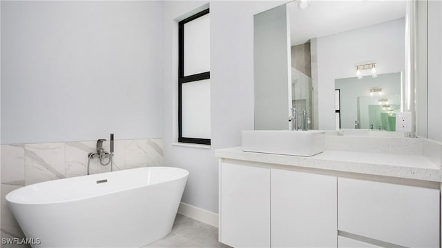 739 David Laird Ln, Lehigh Acres, FL 33974 - full bathroom with a freestanding tub, vanity, tile walls, and tile patterned flooring