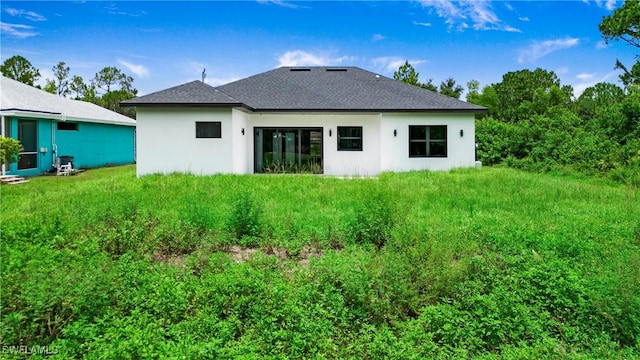 739 David Laird Ln, Lehigh Acres, FL 33974 - rear view of house with stucco siding and a shingled roof