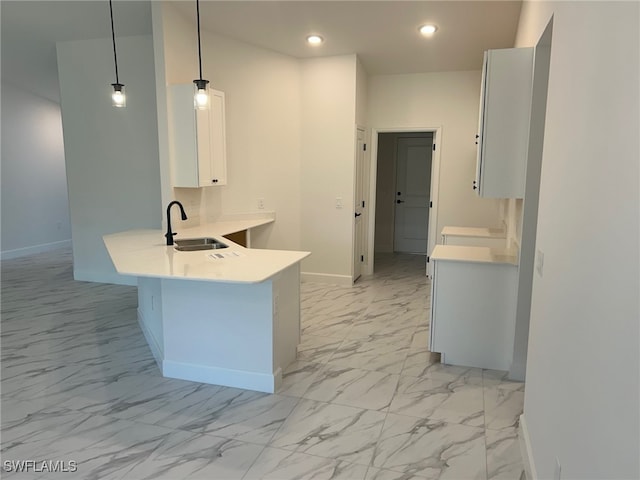 700 Avondale St E, Lehigh Acres, FL 33974 - kitchen featuring white cabinetry, a peninsula, light countertops, light marble finish flooring, and recessed lighting