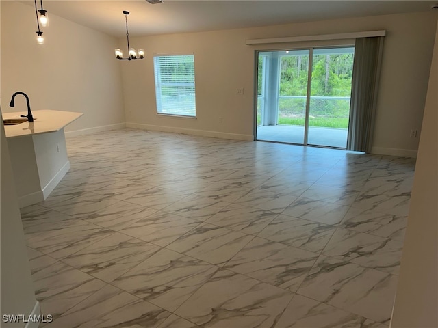 700 Avondale St E, Lehigh Acres, FL 33974 - spare room with marble finish floors and a chandelier