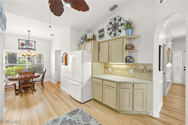 23204 Coconut Shores Dr, Estero, FL 34134 - kitchen with freestanding refrigerator, cream cabinetry, arched walkways, backsplash, and light wood finished floors