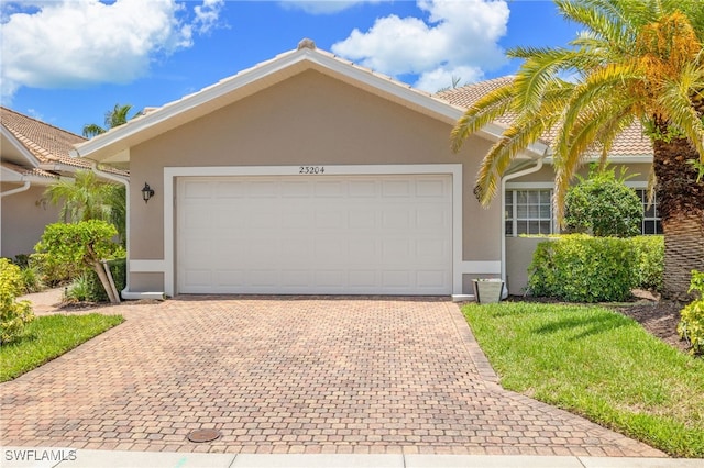 23204 Coconut Shores Dr, Estero, FL 34134 - ranch-style home with a garage, stucco siding, and decorative driveway