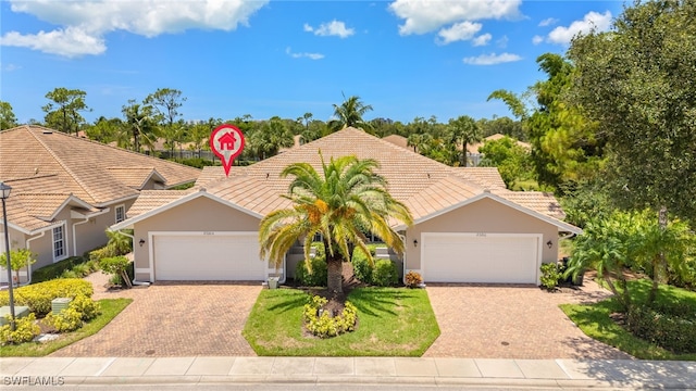 23204 Coconut Shores Dr, Estero, FL 34134 - view of front of house featuring a tile roof, stucco siding, decorative driveway, and an attached garage
