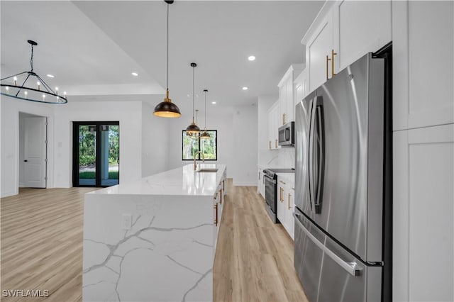 1517 Washington Ave, Lehigh Acres, FL 33972 - kitchen featuring appliances with stainless steel finishes, light wood-style flooring, recessed lighting, white cabinetry, and a center island with sink